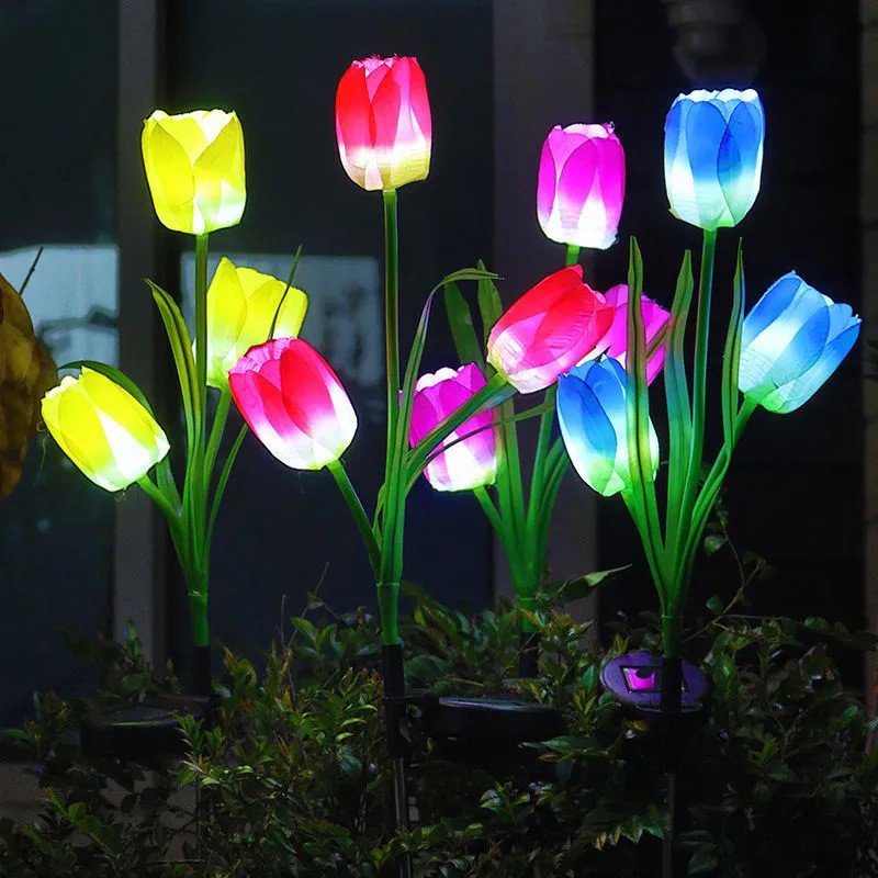 Multi-color solar tulip stakes in a garden bed
